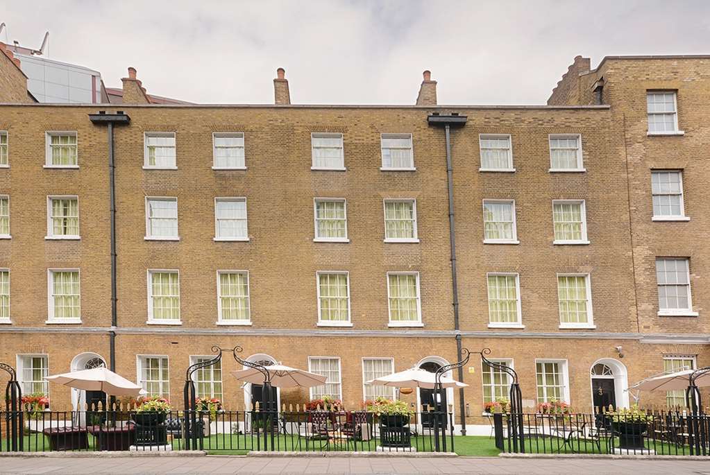 ホテル Montcalm Brewery Townhouse ロンドン エクステリア 写真 The photo shows a brick building with several windows on its facade. The structure appears to be three stories tall, featuring a symmetrical design with multiple windows that have white frames. In front of the building, there is a landscaped area wit