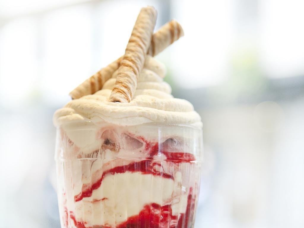 ホテル Montcalm Brewery Townhouse ロンドン エクステリア 写真 The photo shows a delicious dessert in a clear glass dish. It features layers of creamy ice cream or whipped cream, swirled with a vibrant red fruit sauce. Topping the dessert are two rolled wafer sticks, adding a decorative touch. The overall presen