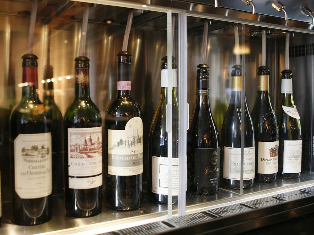 ホテル Montcalm Brewery Townhouse ロンドン エクステリア 写真 The photo depicts a selection of wine bottles displayed in a wine fridge or cooler. The bottles are lined up behind a glass panel, showcasing various types of wine, likely including both red and white varieties. Each bottle has a distinctive label, i