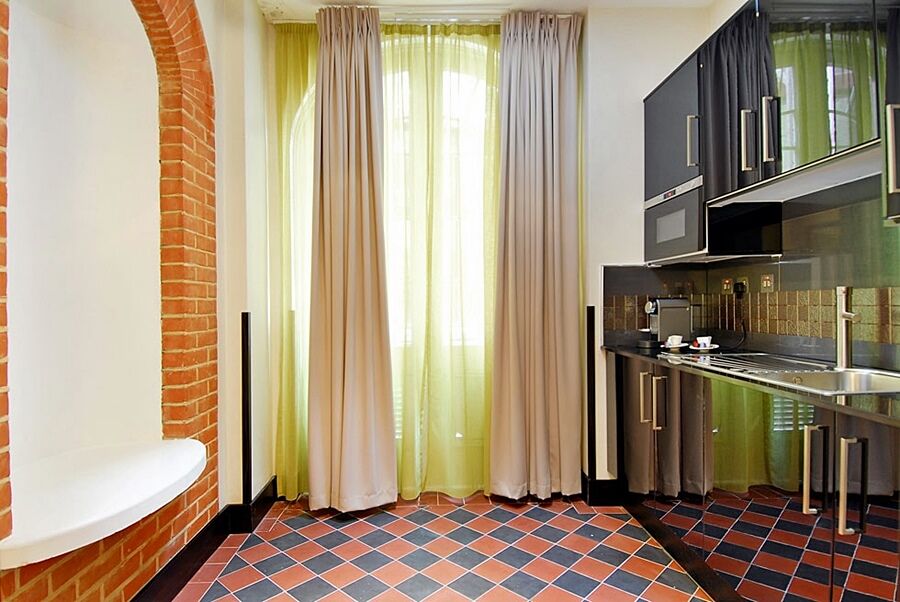 ホテル Montcalm Brewery Townhouse ロンドン エクステリア 写真 The photo shows a kitchen area with modern design elements. There are large, light-colored curtains hanging from the windows, allowing natural light to filter in. The walls are partially exposed brick, giving a warm texture to the room. The flooring 
